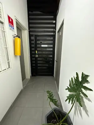 a hallway with a black door and some plants at Aparta estudio amoblado 2 Medellin, San joaquin in Medellín