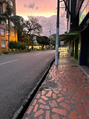 an empty street with a brick sidewalk next to a building at Aparta estudio amoblado 3 Medellin, San joaquin in Medellín