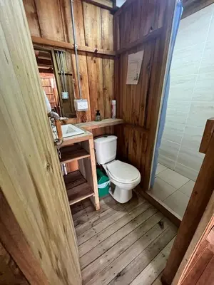 a wooden bathroom with a toilet and a sink at Cabañas Villa Juliana in Jardin