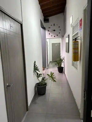 an empty hallway with potted plants in a building at Aparta estudio amoblado 4 Medellín, San Joaquín in Medellín