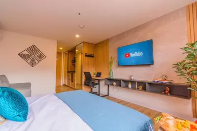 a hotel room with a bed and a tv on the wall at Luxury Suite in El Poblado Co-Work, Gym, Fast WiFi in Medellín