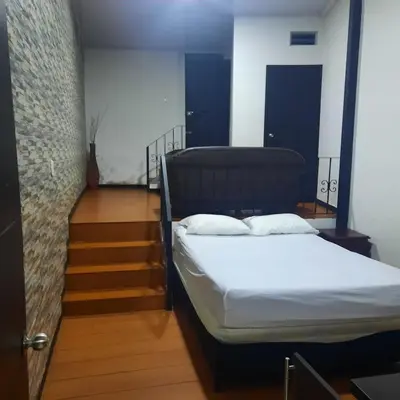 a bedroom with a bed in a room with stairs at Apartaestudio2 Sector Cable-Estadio in Manizales