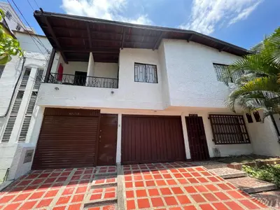 a house with two garage doors and a palm tree at APARTAMENTO AMOBLADO SECTOR LAURELES-ESTADIO hasta 6 personas - Praga in Medellín