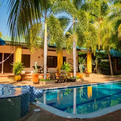 a resort with a swimming pool and palm trees at Casa Guali in Honda