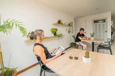 two people sitting at a table reading a book at Descansa en Habitación Privada en Medellín C in Medellín