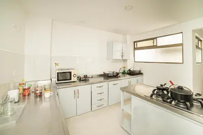 a kitchen with white cabinets and a counter top at Descansa en Habitación Privada en Medellín C in Medellín