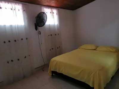 a bedroom with a bed and a fan on the wall at Casa lowcost relajación in La Dorada