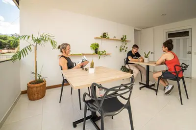 a group of people sitting at tables in a room at Alojamiento en el corazón de Medellín Hab Privada B in Medellín